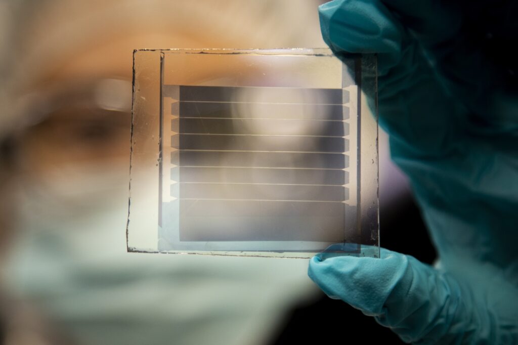 Xinjing Huang, a doctoral student in Forrest's lab, holds a 20% transparency, 30-year solar cell module that she built. The longevity of the design is a major step toward practical windows that provide solar power. Image credit: Robert Coelius, University of Michigan Engineering.