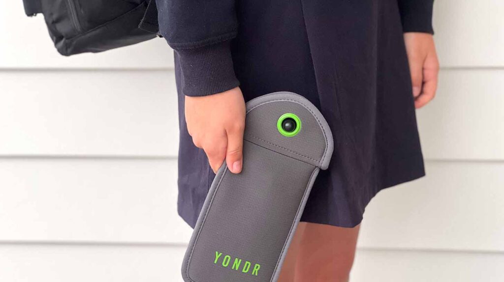 Student using a mobile phone and YONDR lockable phone case pouch. Image credit: Rafael Ben-Ari, Adobe Stock